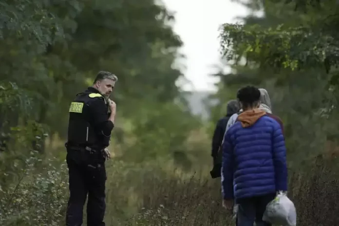 Un policier allemand escorte un groupe de migrants illÃ©gaux @Sipa Press